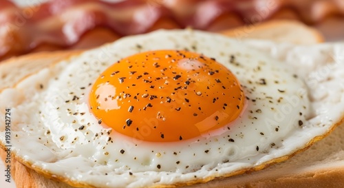 fried egg on a plate, Extreme close-up macro photo of a sunny side up fried egg on a slice of toasted white bread with crispy bacon in the background, bright orange egg yolk with cracked glossy surfac