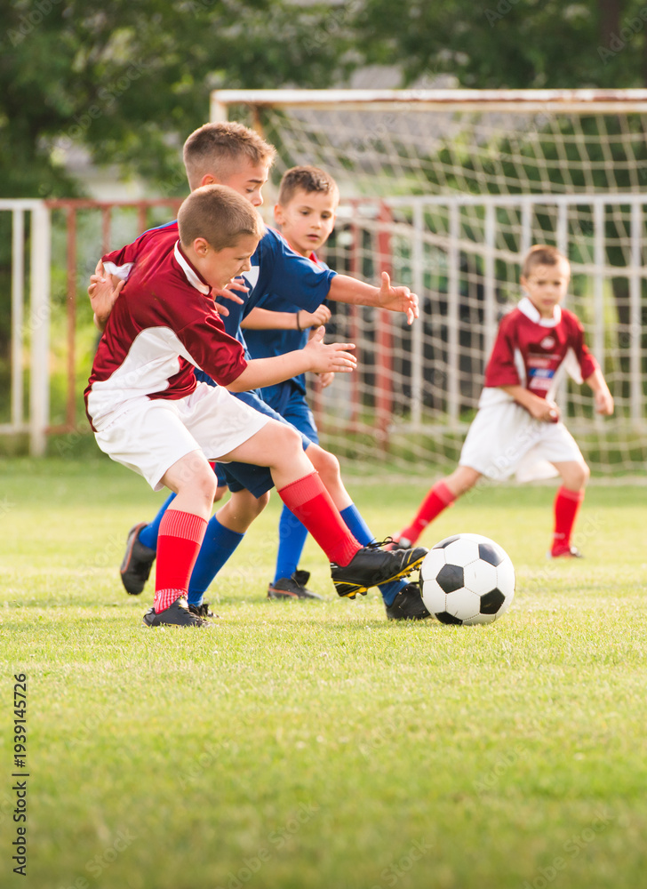 Fototapeta premium Boys kicking football on the sports field