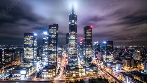 Wallpaper Mural Nighttime cityscape with illuminated skyscrapers and streaking lights under a cloudy sky Torontodigital.ca
