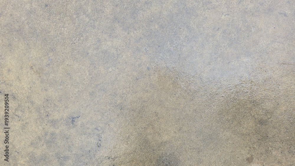 Obraz premium Wet polished concrete floor texture with damp stains. Close-up of a damp cement surface with water absorption patterns. Detailed view of a wet concrete floor after rain.
