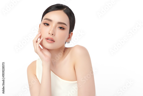 A beautiful young Asian woman with clean, fresh skin against a white background. Skincare, facial treatment, cosmetology, beauty, and spa. An elegant portrait of an Asian woman.