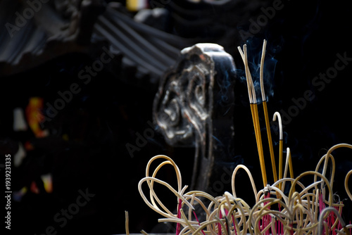 Burning incense stick with smoke in Vietnamese pagoda