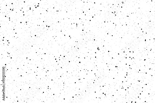 A collection of tiny dark particles randomly dispersed across a bright clean backdrop