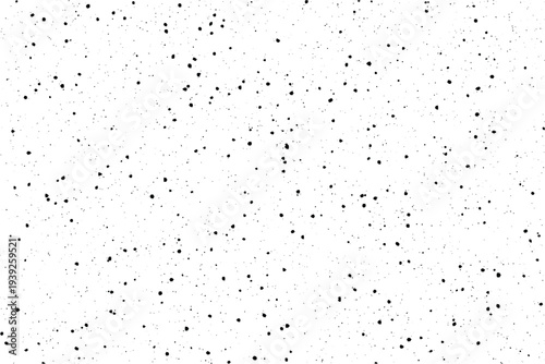 Scattered black specks on a pristine white surface create a subtly distressed visual pattern