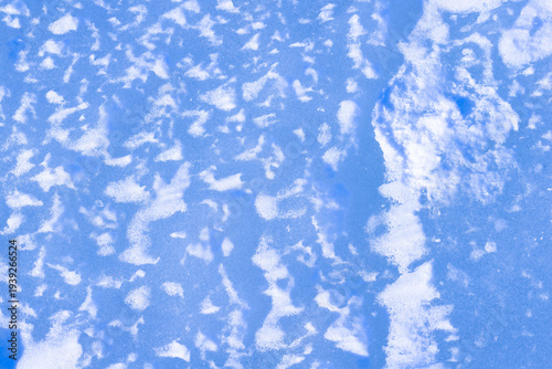 Natural blue ice with snow, rough frozen winter surface