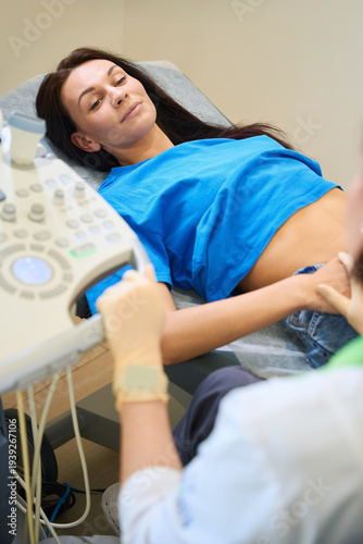 Calm woman receiving ultrasound examination in medical room