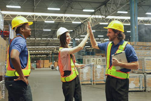 фотографія Group happy workers in the warehouse greeted each other with high-fives showing unity, encouragement cooperation and good spirits among employees in the warehouse organization