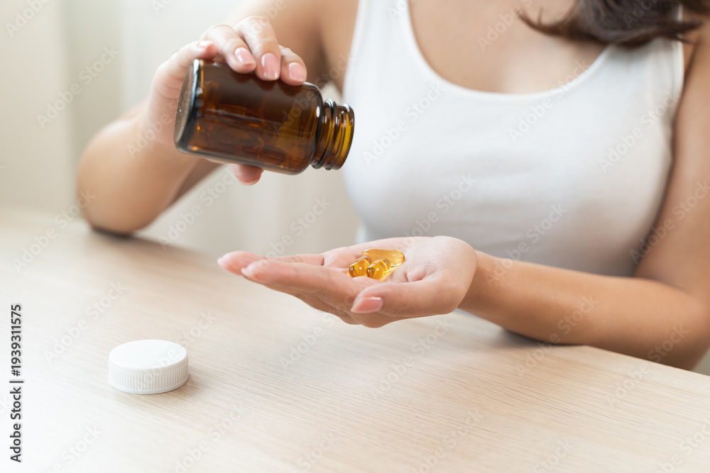 Fototapeta premium person prepare fish oil pills to her hands taking daily supplement