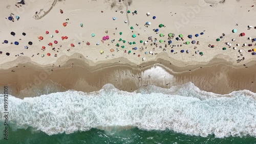 Rio de Janeiro, Brazil, aerial view of Copacabana Beach showing colourful umbrellas and people bathing in the ocean on a summer day. Tropical travel and vacation concept.