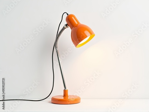 Close-up of an orange lamp sitting on a white table, providing warm lighting