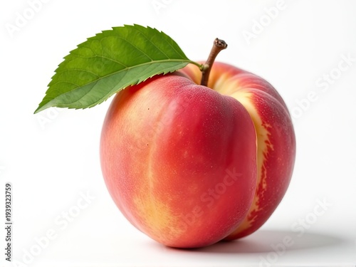 A ripe peach with a single leaf resting on its surface
