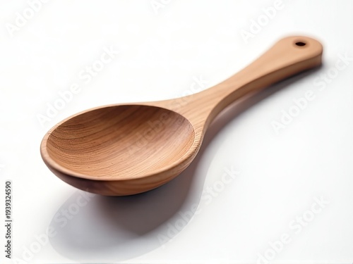 A single wooden spoon placed on a clean white surface, ideal for use in kitchen photography or as a prop in still life compositions