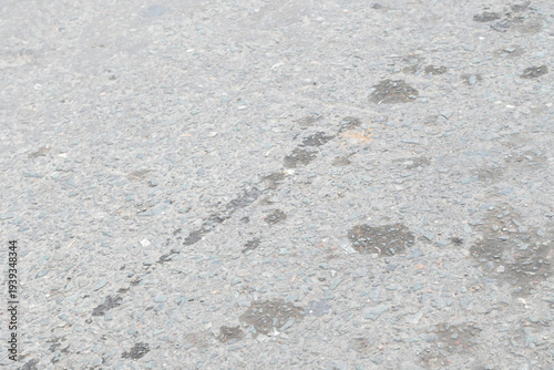 Gray asphalt road surface with texture and stains