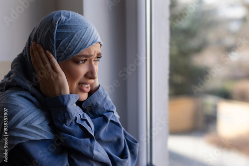 Tableau sur toile Scared woman covering her ears and showing fear while watching explosions outsid