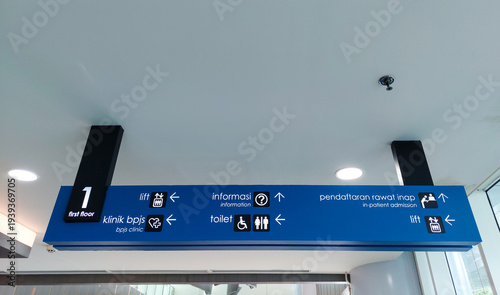 Cuadro en lienzo Blue hospital wayfinding sign in Bahasa Indonesia and English language with symbols, icons, and arrows directing to clinic, elevators, toilets, in-patient admission, and information desk in the lobby
