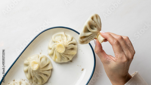 Hand savoring delicate khinkali, these doughy dumplings herald Georgian Supra feasts, evoking Lunar New Year culinary joy