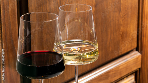 Fotografie Two glasses of ambrosial wine clinking amid rustic wooden ambiance, evoking Bacc