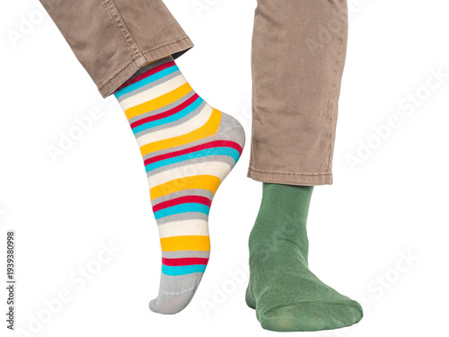 Obraz na płótnie Man wearing mismatched colorful striped and green socks and light brown pants without shoes