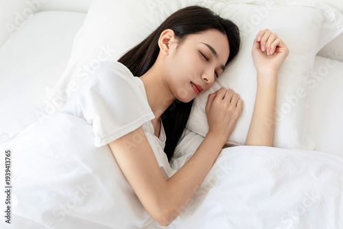 Fotografie A young woman sleeping in the bed