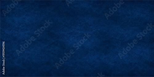 Dark blue grunge background with a textured denim fabric pattern and vintage paper material surface providing ample copy space for design