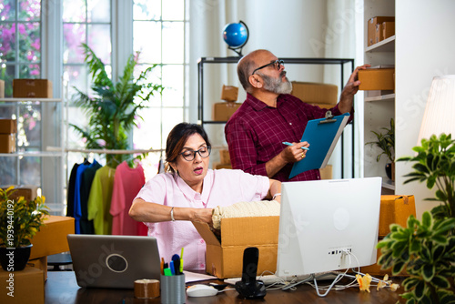 Indian senior couple packing garment while doing E-commerce business from home office