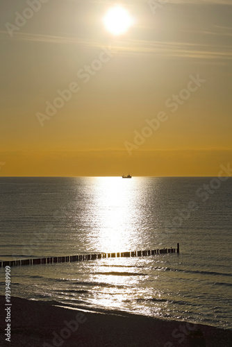 As the sun sets, its golden light illuminates the Baltic Sea, as seen from Mielno in Poland