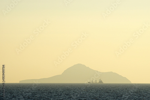 Silhouette of an Island in the Mediterranean, wiht a ship in front of it