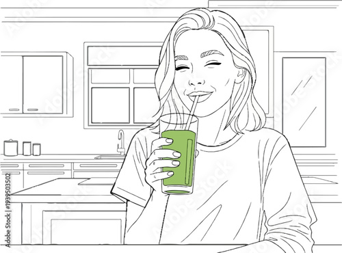 Woman joyfully sips a green beverage from a glass with a straw in a kitchen