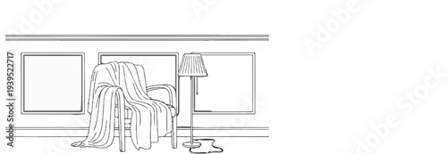 Cozy armchair draped with blanket beside floor lamp and empty frames