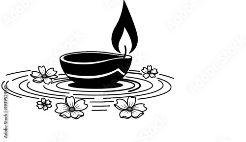 A lit diwa floats on rippling water surrounded by delicate flowers