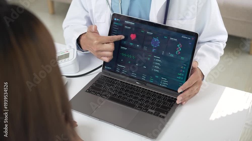 Doctor showing medical test results on a laptop to a female patient in a modern clinic.