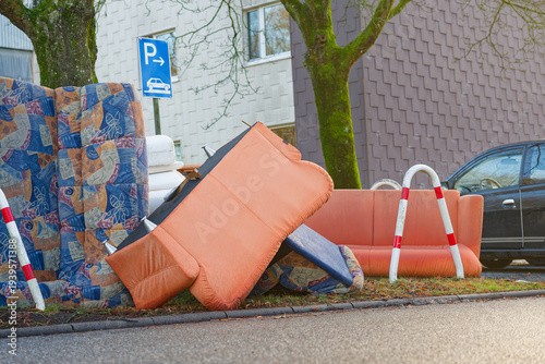 Bulky pickup pile of sofas and chairs left roadside for collection.