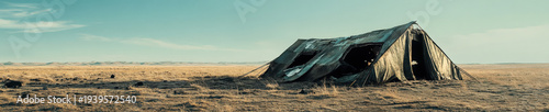 Abandoned Collapsed Tent Structure in Barren Desert Landscape with Teal Sky - Desertion and Decay Concept