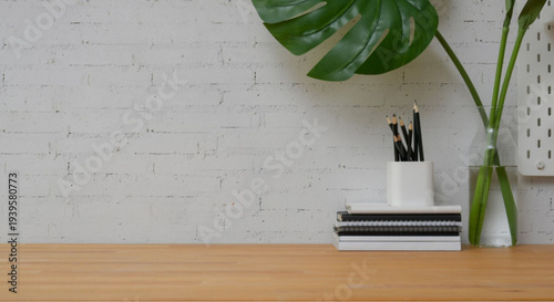 Minimalist workspace with notebooks and pencils on wooden desk