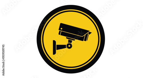 Close-up of a black security camera icon on a yellow circular sign with a black border against a white background.