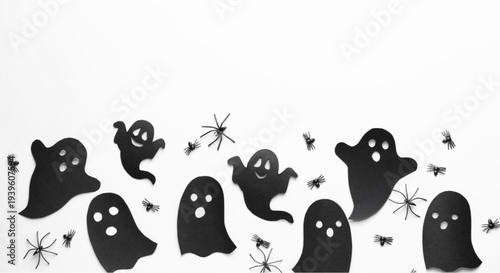Spooky Halloween decorations with ghost cutouts and plastic spiders