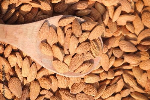 Dried almonds. Almond kernels lie in wooden spoon. Top view of nuts close-up. Advertising photography for marketplaces or online stores.