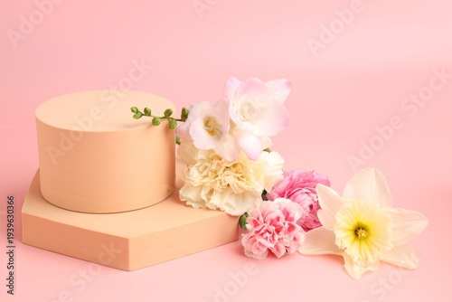 Empty podiums and spring flowers on pink background, closeup. Mockup for design