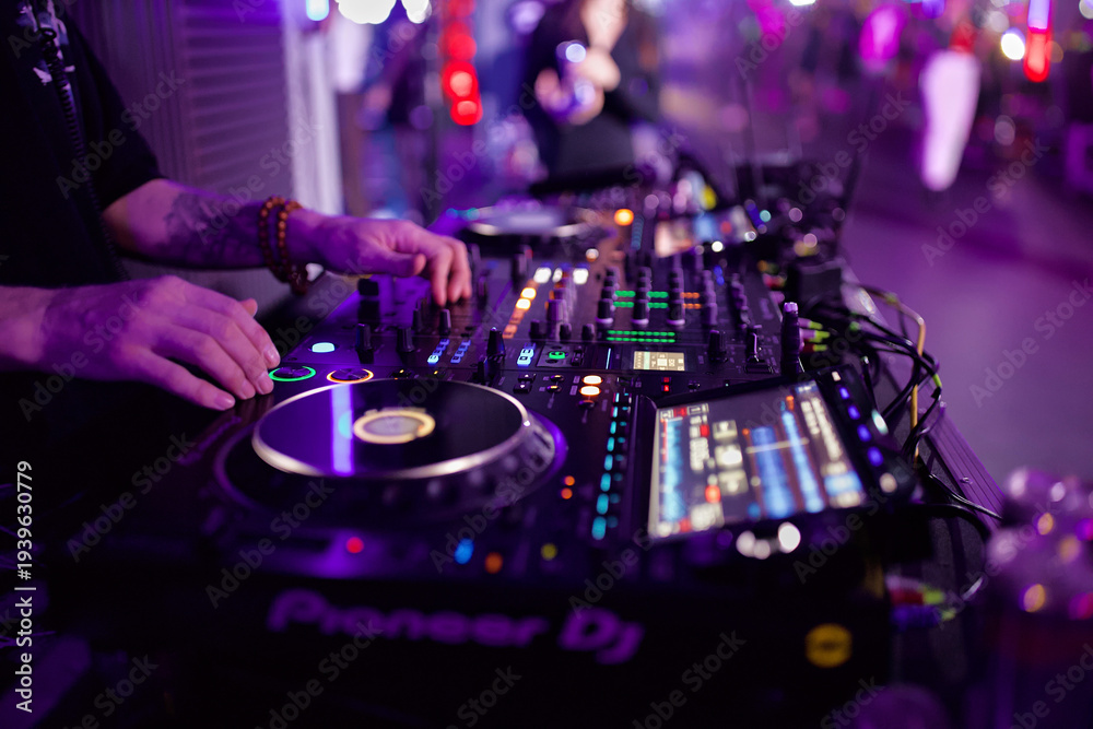 Obraz premium DJ Mixing Music on a Console at a Nightclub