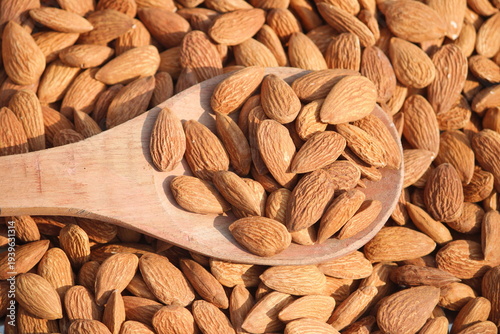 Dried almonds. Almond kernels lie in wooden spoon. Top view of nuts close-up. Advertising photography for marketplaces or online stores.