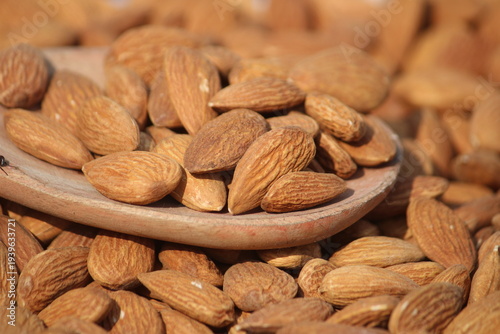 Dried almonds. Almond kernels lie in wooden spoon. Top view of nuts close-up. Advertising photography for marketplaces or online stores.