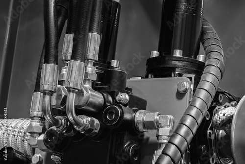 Industrial machine concept, industrial hydraulic machine with rubber and metal pipes high pressure pipes, real technical image.