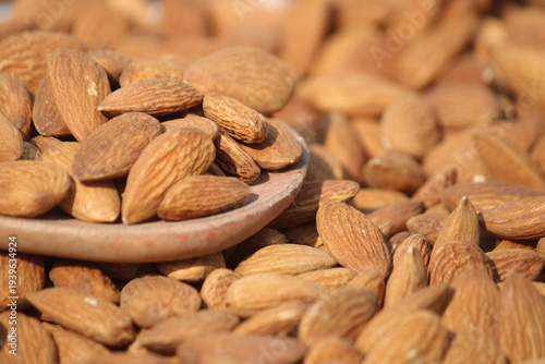 Dried almonds. Almond kernels lie in wooden spoon. Top view of nuts close-up. Advertising photography for marketplaces or online stores.