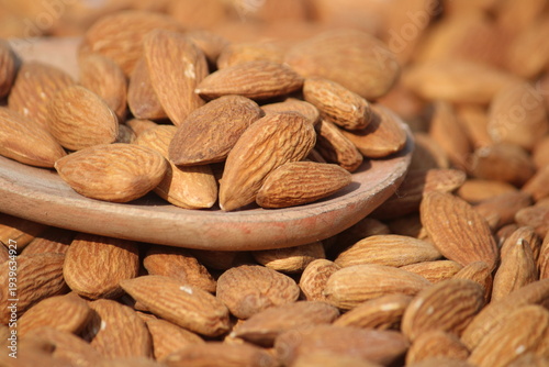 Dried almonds. Almond kernels lie in wooden spoon. Top view of nuts close-up. Advertising photography for marketplaces or online stores.
