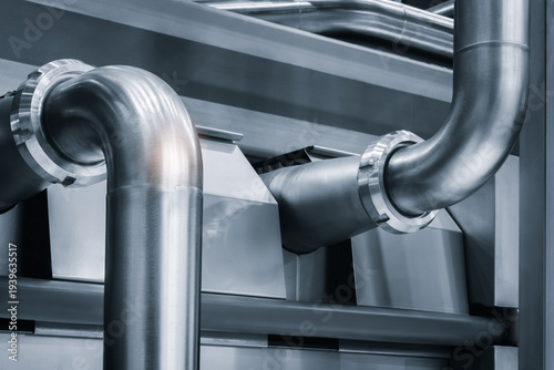 Industrial medicine production machine in pharmaceutical factory with many shiny stainless steel parts as industrial concept background