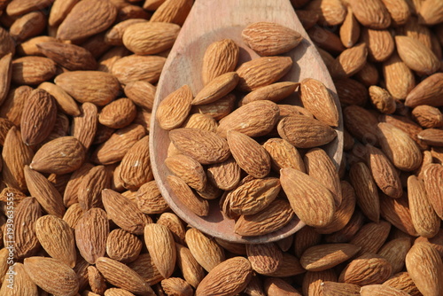 Dried almonds. Almond kernels lie in wooden spoon. Top view of nuts close-up. Advertising photography for marketplaces or online stores.