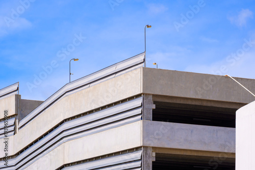 Modern concrete parking garage building against blue sky. Minimalist architectural design and urban infrastructure exterior.