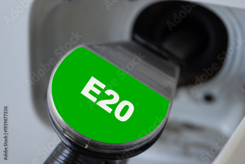 Tableau sur toile green fuel nozzle with e20 label inserted into a car gas tank, close up of fueli