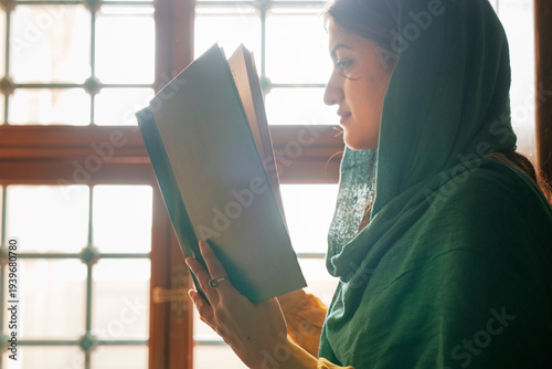 Muslim woman praying in mosque, reading Quran
