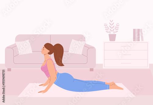 Young female practicing yoga. Woman in cobra pose in a cozy living room on a mat. Interior background for flexibility, fitness, health and relaxation lifestyle design.
